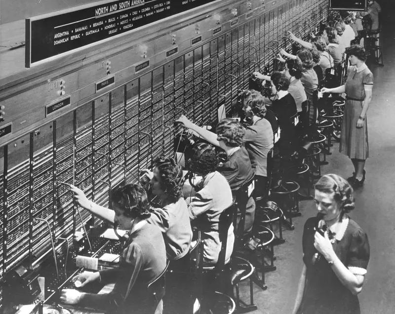 Rows of telephone operators connecting calls at a Bell System switchboard